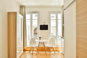 尼斯美丽的家 - 丽都一室公寓的一间带桌子和白色椅子的用餐室