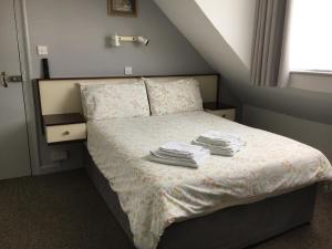 圣赫利尔泽西Avoca Villa Guest House的一间卧室配有带毛巾的床