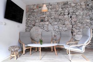 科巴里德Premium Hostel Kobarid的配有桌椅和石墙的房间