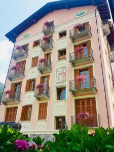 利莫内皮埃蒙特Villa Teresa的粉红色的建筑,设有花盒和阳台