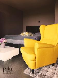 多博沃Apartma Sobe Pulec的一间卧室配有黄色椅子和一张床