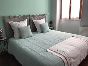 萨利耶德贝阿尔恩AUX ROSIERS的一间卧室配有一张带枕头的大床