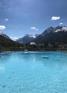 克洛斯特斯Studio in Klosters的一座大池的蓝色海水,背景是群山