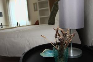 SolarussaIs Scabas Guestrooms的床头桌旁的灯和花瓶