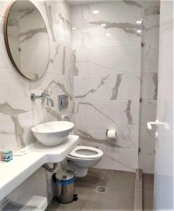 阿达玛斯Corali Hotel的一间带卫生间、水槽和镜子的浴室