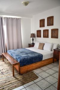 圣萨尔瓦多Cinco Hotel B&B的一间卧室配有一张带蓝色毯子的床
