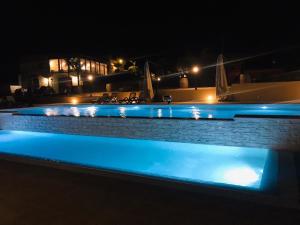 阿格里真托Agriturismo La Casa di Bacco的夜晚的游泳池,灯光蓝色