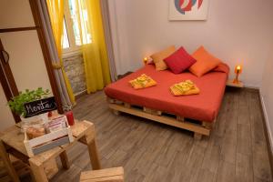 斯培西亚拉尔卡迪威B&B酒店的一间卧室配有红色床单和橙色枕头。
