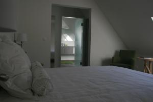 Hofstade阿库兰德住宿加早餐旅馆的卧室配有白色的床和绿色椅子