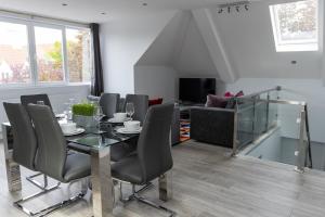 哈罗London Northwick Park Serviced Apartments by Riis Property的一间带桌椅和沙发的用餐室