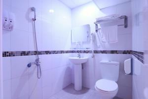 中坜以琳商务旅馆的白色的浴室设有卫生间和水槽。
