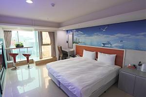 中坜以琳商务旅馆的卧室配有一张大床,墙上挂有绘画作品