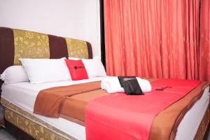 巨港RedDoorz near Palembang Square Mall 2的一间卧室配有两张红色窗帘