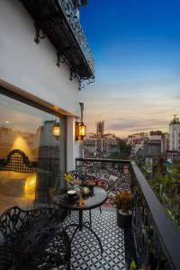 河内Hanoi Esplendor Hotel and Spa的设有一个配有桌椅并享有美景的阳台。