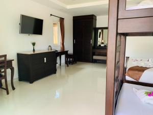 湄南海滩香格里拉哈简易别墅酒店的一间卧室配有一张床、一张书桌和一台电视