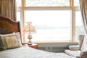 维多利亚达什伍德庄园海滨住宿加早餐酒店的卧室配有床、椅子和窗户。