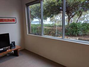 奥尔巴尼Hanover Bay Apartments的客房设有窗户和带电视的桌子。