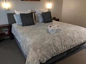 奥尔巴尼Hanover Bay Apartments的一间卧室配有一张床,上面有两条毛巾