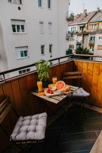 布达佩斯布达中心公寓的阳台上的桌子上摆放着食物和饮料