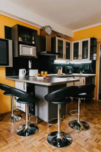 布达佩斯布达中心公寓的厨房配有黑色橱柜和带吧台凳的台面