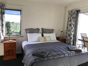 北哈夫洛克Bluebell Lodge and Cottage的一间卧室设有一张大床和一个窗户。