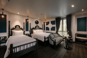 河内Hanoi Esplendor Hotel and Spa的酒店客房,配有两张床和椅子