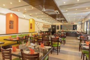卡兰古特Kyriad Prestige Calangute Goa by OTHPL的餐厅内带桌椅的用餐室
