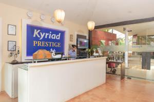 卡兰古特Kyriad Prestige Calangute Goa by OTHPL的站在一个高贵的名牌商店柜台上的女人