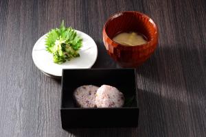 涩川市Akari no Yado Okabe的一张桌子,上面放着一盘西兰花和一碗汤