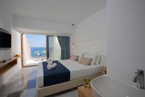 罗希姆诺Archipelagos Hotel的一间卧室配有一张床、一个浴缸和一台电视。