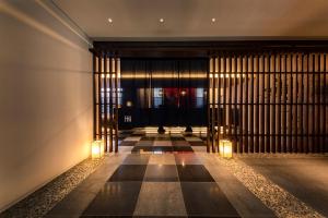 大阪Hotel Hanshin Annex Osaka的一条空的走廊,有两个灯和一扇门