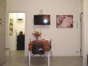塞斯托-圣乔凡尼Casa Laura的一间用餐室,配有一张桌子和一台墙上的电视