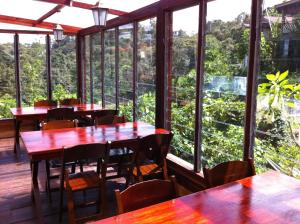 昆达桑山里度假村的餐厅设有桌椅和大窗户。