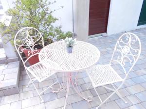 普莱克Family house Bacalja的白色桌子和两把椅子,盆栽