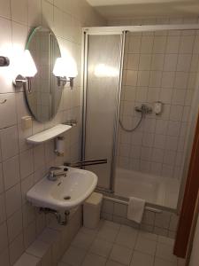 RottaHotel Landgut Ochsenkopf的一间带水槽、淋浴和镜子的浴室