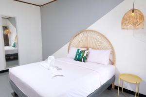 班达楠榜Rarem Bed & Breakfast的卧室配有白色的床和黄色凳子