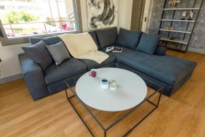 海若克利欧Heraklion chic and minimalistic apartment with sea view的客厅配有蓝色的沙发和白色的桌子