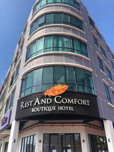 瓜拉丁加奴Rest And Comfort Boutique Hotel的一座高大的建筑,前面有标志