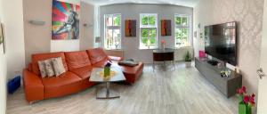 爱尔福特Ferienhaus Pilse 3的客厅配有橙色沙发和桌子