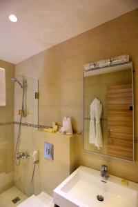 埃赫登Mist Hotel & Spa的一间带水槽、淋浴和镜子的浴室