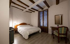 蒙塔尼约斯Casa Rural Pradas的卧室配有1张床、1张桌子和1把椅子