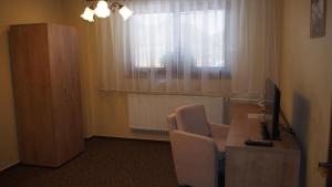 米哈洛夫采Hotel Slnecny Dvor的客房设有一张桌子、一把椅子和一台电脑