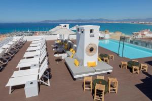 埃尔阿雷纳尔whala!fun的一个带游泳池和桌椅的度假酒店