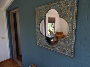 马伦-凯塞尔Roer, huisje aan de Maas的一面墙上的镜子,一面是蓝色的墙