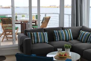 奥尔本尼兹Hausboot Yellow submarine的带沙发的客厅,享有水景
