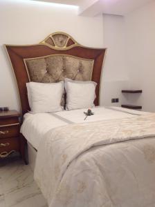 贝尼多姆Apartamento Daniela的一间卧室配有一张大床和木制床头板