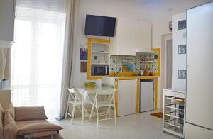 维耶特里LA SCALINATELLA -vista mare-的一间带桌子的厨房和一间带冰箱的厨房