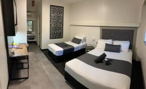 凯瑟琳The Stuart Hotel-Motel的酒店客房设有两张床和一张桌子。
