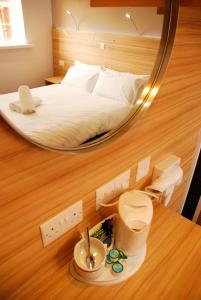 贝尔法斯特皇后植物园休憩酒店的卧室配有一张床和一面镜子,位于地板上