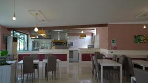 马格拉科伦坡酒店的一间带桌椅的餐厅和一间厨房